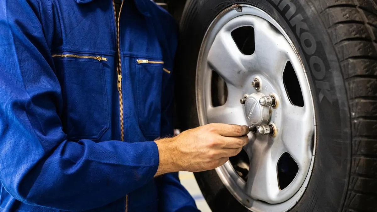 Mécanicien travaillant sur une roue de voiture